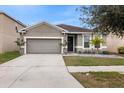 Two-story house with gray siding, two-car garage, and landscaped yard at 12152 Ledbury Commons Dr, Gibsonton, FL 33534