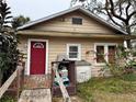 Tan single story house with red door, small deck, and landscaping at 1602 Saffold Park Dr, Ruskin, FL 33570