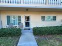 Condo entry with two chairs and well-maintained shrubs at 2222 Americus N Blvd # 2, Clearwater, FL 33763