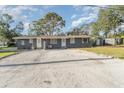 Front view of a gray duplex with parking and a large yard at 281 Grove Rd, Venice, FL 34293