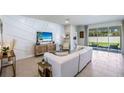 Living area featuring white sofas and sliding glass doors at 32474 Osprey Peak Way, San Antonio, FL 33576