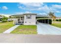 Front view of a white mobile home with carport and landscaping at 37350 Tropical Dr, Zephyrhills, FL 33541