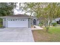 White garage door, landscaped yard, and a charming house exterior at 38902 Inez Ave, Zephyrhills, FL 33542