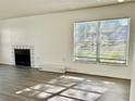 Bright living room with gray wood-look flooring, a fireplace, and a window with natural light at 4208 Winding Moss Trl # 102, Tampa, FL 33613