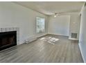 Bright living room with gray wood-look flooring, a fireplace, and a window with natural light at 4208 Winding Moss Trl # 102, Tampa, FL 33613