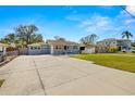 Spacious front yard with concrete driveway and well-manicured lawn at 4424 W Bay Villa Ave, Tampa, FL 33611