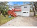 Two-story house with a deck, garage, and landscaped yard at 5004 Osprey Ln, New Port Richey, FL 34652