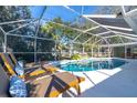 Inviting pool area with lounge chairs and a screened enclosure at 5105 W Country Club Dr, Sarasota, FL 34243