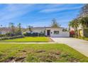 White single story home with palm trees and a manicured lawn at 5934 Bayou Grande Ne Blvd, St Petersburg, FL 33703