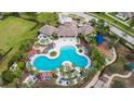 Community pool and clubhouse with surrounding landscape at 6834 Blue Moon Way, Sun City Center, FL 33573