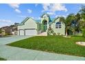 Charming light green house with a three-car garage and nicely landscaped yard at 711 Eagle Ln, Apollo Beach, FL 33572