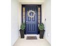 Inviting front door entrance with a decorative wreath and potted plants at 7395 Steer Blade Dr, Zephyrhills, FL 33541