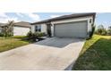 One story home with gray garage door and a wide driveway.Landscaped lawn at 9215 Royal River Cir, Parrish, FL 34219