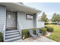 Front entrance of condo with stairs, landscaping, and seating area at 1018 Caravel Ct, Tarpon Springs, FL 34689