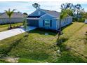 Newly built home with a grassy yard and palm trees at 105 Oakwood Ct, Rotonda West, FL 33947