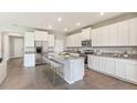 Modern kitchen with white cabinets, granite counters, and an island at 10521 Bridgegate Heights Loop, San Antonio, FL 33576