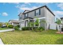 Two-story house with gray siding, neutral garage door, and landscaped lawn at 13614 Wild Ginger St, Riverview, FL 33579