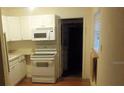 Small kitchen with white cabinets and appliances at 1601 Essex N Dr, St Petersburg, FL 33710