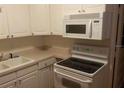 White cabinets, microwave, and electric stove top at 1601 Essex N Dr, St Petersburg, FL 33710