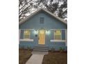 Newly renovated home with a charming light blue exterior, yellow door, and landscaping at 1751 Yale S St, St Petersburg, FL 33711