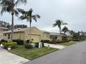 Street view of houses with tan exteriors, palm trees, and landscaping at 2124 Sifield Greens Way # 11, Sun City Center, FL 33573