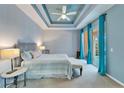 Bright main bedroom with tray ceiling and sliding glass doors at 302 Latitude Pl, Apollo Beach, FL 33572