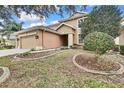 Two-story house exterior with tan siding, attached two-car garage and landscaped yard at 4381 Caliquen Dr, Brooksville, FL 34604