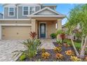 Two-story house with gray siding, tan accents, and a landscaped front yard at 5636 Silver Sun Dr, Apollo Beach, FL 33572