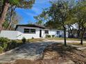 White house with a dark brown roof and a nicely landscaped yard at 6413 N 48Th St, Tampa, FL 33610