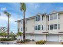 Three-unit building, light beige siding, attached garages, and landscaping at 9341 Blind Pass Rd, St Pete Beach, FL 33706