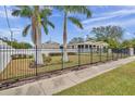 House behind black fence, palm trees in the foreground at 2715 9Th N Ave, St Petersburg, FL 33713