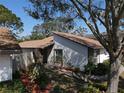 The front of this home showcases a unique architectural style, with landscaped garden and a brick wall at 10303 Chadbourne Dr, Tampa, FL 33624