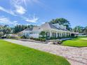 House with a long driveway, side yard and manicured landscaping at 1503 Limona Rd, Brandon, FL 33510