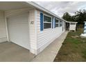 Side view of a white mobile home showcasing the garage and landscaping at 1710 7Th Sw St # 83, Ruskin, FL 33570