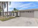 Tan colored house with attached garage and landscaping at 407 Boca Ciega Point N Blvd, St Petersburg, FL 33708