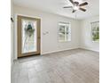 Bright living room featuring gray tile floors and a ceiling fan at 9415 Forest Hills Dr, Tampa, FL 33612