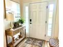 Bright and airy entryway with console table, lamp, and decorative plants at 11036 Paradise Point Way, New Port Richey, FL 34654