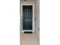 Dark green front door with a welcome mat and decor at 12772 Achasta Blvd, Hudson, FL 34669