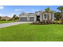 House exterior with gray siding, stone accents, and a three-car garage at 15143 Sea Salt Way, Bradenton, FL 34211