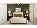 Bedroom with a full bed, green accent wall, and modern decor at 17638 Happytrails St, Land O Lakes, FL 34638