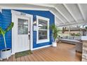 Front porch with white door, wooden flooring, and potted plants at 207 E Selma Ave, Tampa, FL 33603