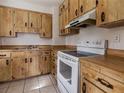 Functional kitchen with wood cabinets, white appliances, and tile floor at 316 W Genesee St, Tampa, FL 33603