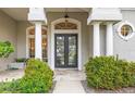 Elegant entryway with double doors, columns, and lush landscaping at 4339 Cheval Blvd, Lutz, FL 33558