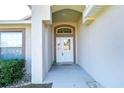 White front door with arched window and sidelights at 6932 Oakcrest Way, Zephyrhills, FL 33542