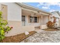 Home exterior showcasing a brick facade, covered entryway and walkway at 7051 Nova Scotia Dr, Port Richey, FL 34668