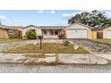 Ranch-style house with a paved driveway and landscaped yard at 7051 Nova Scotia Dr, Port Richey, FL 34668