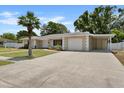 House exterior with driveway and a palm tree in front at 7304 Gates Cir, Spring Hill, FL 34606