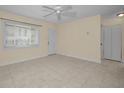 Bright living room with tile floors, neutral paint, a ceiling fan, and a large window with blinds at 925 67Th S St, St Petersburg, FL 33707