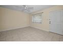 Bright living room with tile floors, neutral paint, a ceiling fan, and a large window with blinds at 925 67Th S St, St Petersburg, FL 33707