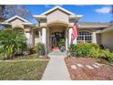 House exterior with columns, landscaping, and an American flag at 12031 Sapphire Dr, Spring Hill, FL 34609